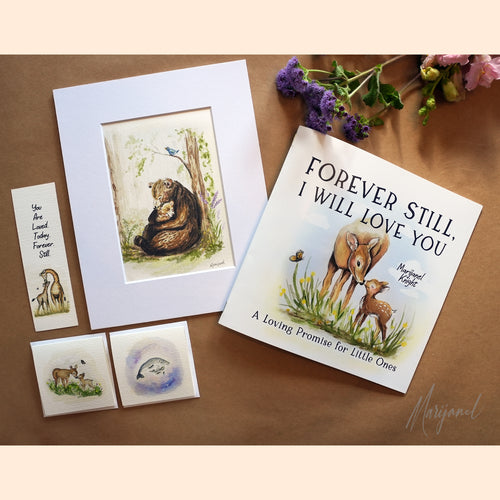 A styled flat-lay of a children's memory book and matching keepsake items on a brown surface. The book cover reads 'FOREVER STILL, I WILL LOVE YOU' and shows an illustration of a bear and deer.